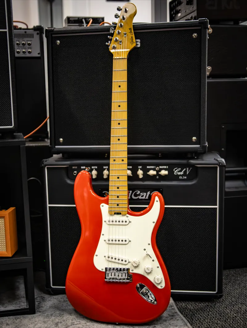 An electric guitar in front of amplifiers