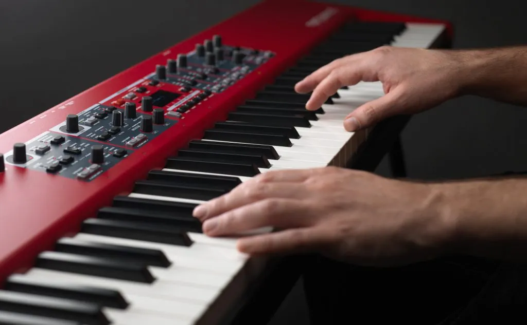 Hands playing a stage keyboard